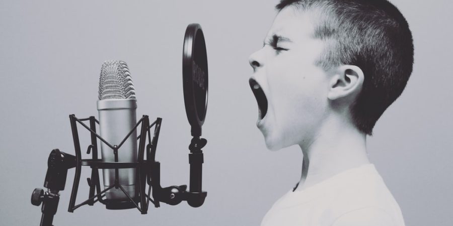 Boy yelling into a podcast microphone